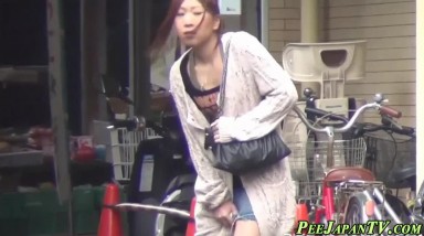日本街头女孩尿急找没人的地方解决被发现，硬是忍着尿完才提裤子骂骂咧咧的走了
